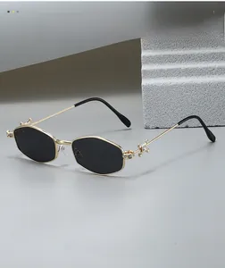 Macro detail of hexagonal metal sunglasses featuring rhinestone hinges and gold frames