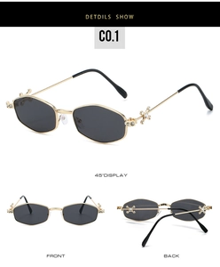Close-up of hexagonal metal sunglasses with crystal cross hinges and grey lenses