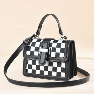 Houndstooth textured crossbody bag with silver buckle and black leather strap detailing