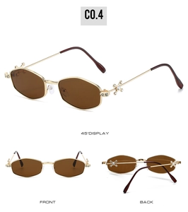Detail view of gold geometric sunglasses with rhinestone cross star accents and brown lenses
