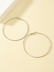 Close-up of minimalist large silver hoop earrings with a slim circular metallic design
