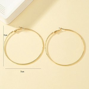 Detailed view of 7cm diameter large gold hoop earrings with smooth metallic finish