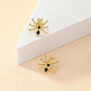 Dettaglio di orecchini a formica dorata con smalto nero su supporto geometrico moderno