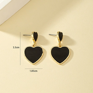Détail des boucles d'oreilles cœur en émail montrant 3.3 cm de hauteur et 1.85 cm de largeur