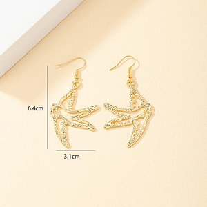Detail of gold swallow drop earrings with hammered texture and 6.4cm length