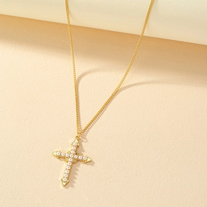 Collier croix dorée élégant avec perles blanches sur fond beige minimaliste