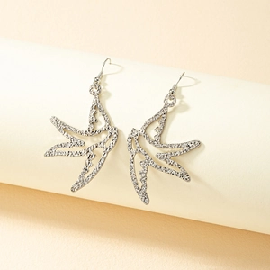 Macro detail of silver swallow bird earrings with textured lava finish and elegant design