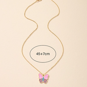 Goldene Schmetterlingskette mit Emaille-Sternen und 45+7cm Kette auf Sandhintergrund