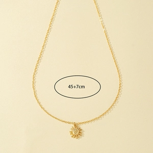 Detail of gold sun pendant necklace featuring sunburst texture and 45+7cm adjustable chain