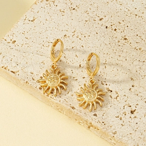 Minimalist golden sun huggie hoop earrings with vintage sun face relief on stone
