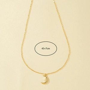 Detail of gold crescent moon necklace with face texture and 45+7cm chain length measurement