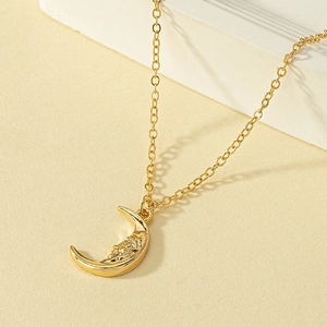 Golden crescent moon face pendant necklace with vintage embossed sun moon details