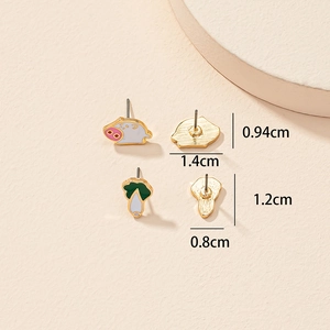 Détail de boucles d'oreilles cochon et chou avec dimensions sur support de présentation