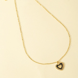 Collier cœur doré avec motif rayon de soleil et pendentif en émail noir texturé