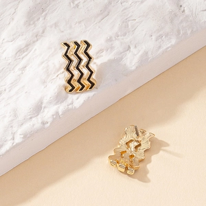 Minimalist wave-shaped gold enamel earrings shown from front and back on stone base