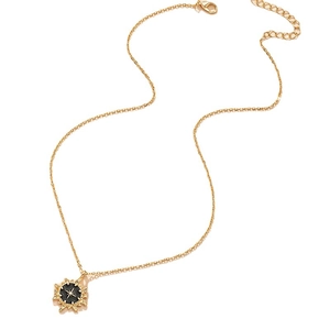 Golden sunburst star necklace with black enamel pendant and delicate cable chain jewelry