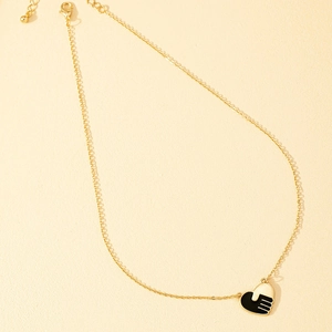 Golden chain necklace with black and white enamel heart pendant showing handshake