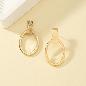 Minimalist gold alloy oval drop earrings shown in front and back views on beige surface