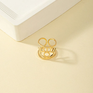 Adjustable gold evil eye open ring featuring eyelash cutout design on stone backdrop