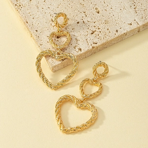 Boucles d'oreilles pendantes coeur triple en or avec texture torsadée de style bohème