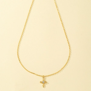 Collier croix minimaliste doré orné d'un pendentif en zircone cubique étincelant