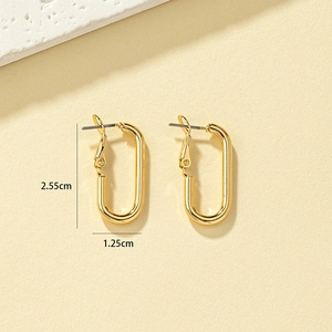 Dettaglio di orecchini geometrici dorati con misure di 2,55 cm per 1,25 cm