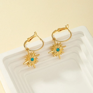 Détail des boucles d'oreilles créoles étoile en or 18K avec pierre centrale turquoise
