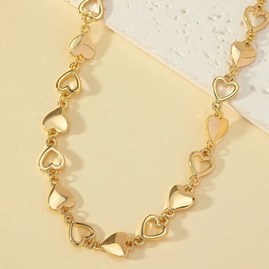 Elegant gold hollow heart link necklace with polished finish on a minimalist stone base