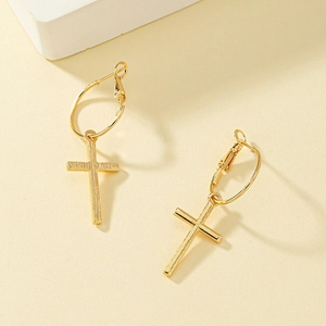Boucles d'oreilles créoles croix dorées avec texture brossée vues de dessus