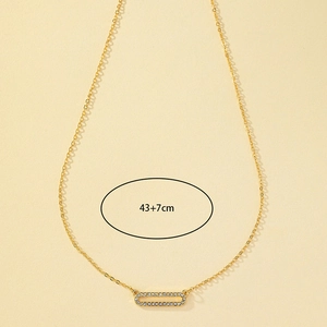 Detail view of a gold geometric necklace with white rhinestones and 43+7cm measurement