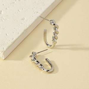 Minimalist silver twisted rope texture U-shaped alloy stud earrings on a stone background
