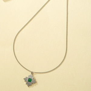 Vintage silver sunburst necklace featuring a green cat eye stone in a geometric pendant
