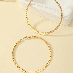 Detailed view of large gold hoop earrings with twisted woven texture and high polished finish