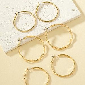 Three-piece gold hoop earring set with smooth, twisted, and textured finish on stone