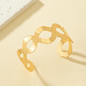 Polished gold wave open bangle with a geometric infinity design on a neutral background
