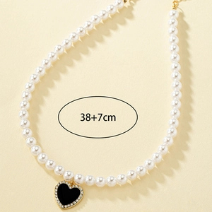 Collier de perles avec pendentif cœur en émail noir et cristaux pavés dorés