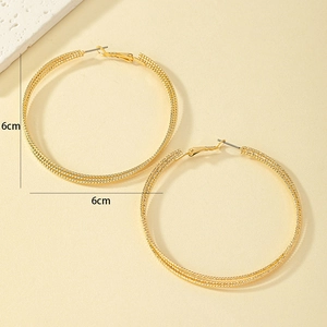 Detailed view of 6cm gold multi-layered twisted hoop earrings with fine wire texture