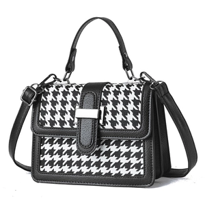 Classic houndstooth patterned crossbody bag with black leather trim and metal clasp