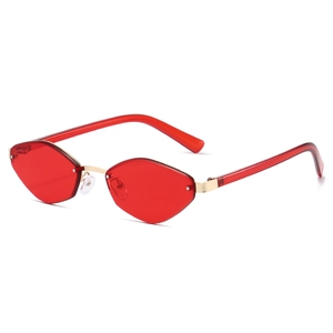 Retro polygon sunglasses with transparent red lenses and golden metal frame on white background