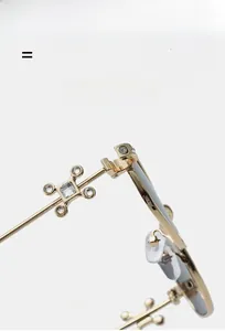 Macro detail of golden metal glasses hinge with cross-shaped rhinestone decoration