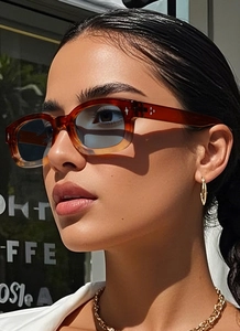 Gros plan de lunettes de soleil vintage ambre et bleu portées par un mannequin