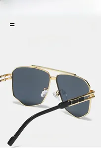 Detail of square gold metal sunglasses featuring double bridge and black textured temples