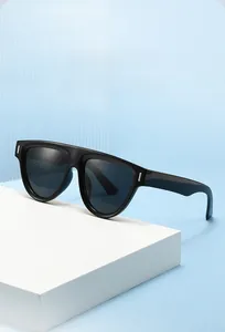Détail de lunettes de soleil noires surdimensionnées avec rivets argentés sur fond texturé