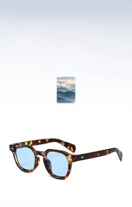 Détail de lunettes de soleil écaillées avec verres bleus et rivets en argent