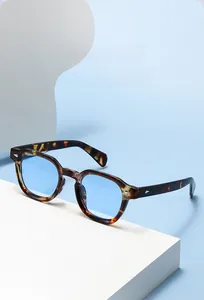 Détail de lunettes de soleil géométriques écaille avec verres bleu clair et décor argent