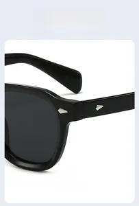 Détails macro des rivets losanges argentés sur lunettes de soleil noires et charnières