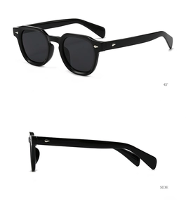 Détail de lunettes de soleil noires à monture épaisse avec rivets fléchés en argent