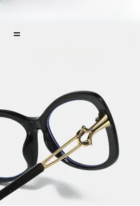 Detailed close-up of golden metal hinges on black sunglasses showing intricate hollow design