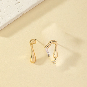 Minimalist gold asymmetric musical note earrings in high gloss finish on neutral stone