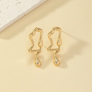 Detail of minimalist fluid gold music note earrings with a liquid lava metallic finish